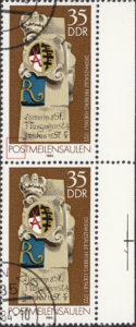 GDR 1984 Postal milestones postage stamp plate flaw Inner top of letter O in POSTMEILENSÄULEN damaged.